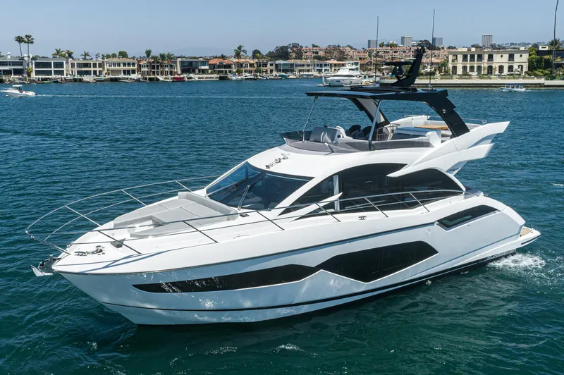 Slide: The Image of 2021 Sunseeker Manhattan 55 yacht cruising in a scenic harbor. - 33