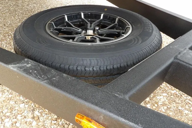 Slide: The Image of Spare tire on Crestliner 1870 Retriever FCC trailer, 2026 model, on gravel surface. - 39