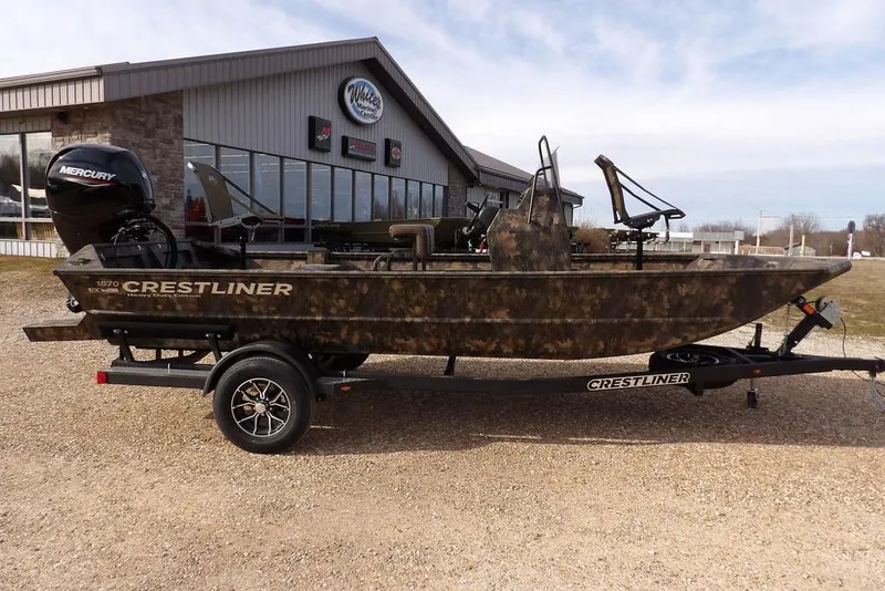 Slide: The Image of 2026 Crestliner 1870 Retriever FCC boat with Mercury engine on trailer, parked outside dealership. - 5