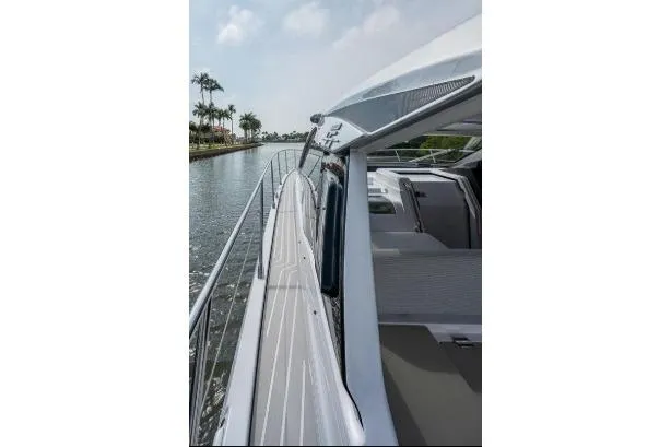 Slide: The Image of 2022 Azimut Atlantis 45 yacht cruising along a scenic waterway with palm trees. - 10