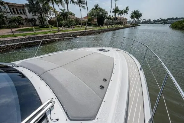 Slide: The Image of 2022 Azimut Atlantis 45 yacht cruising along a scenic, palm-lined waterway. - 13