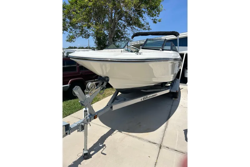 The Image of 2020 Sea Ray SPX 210 Outboard boat on trailer under cloudy sky. - 0