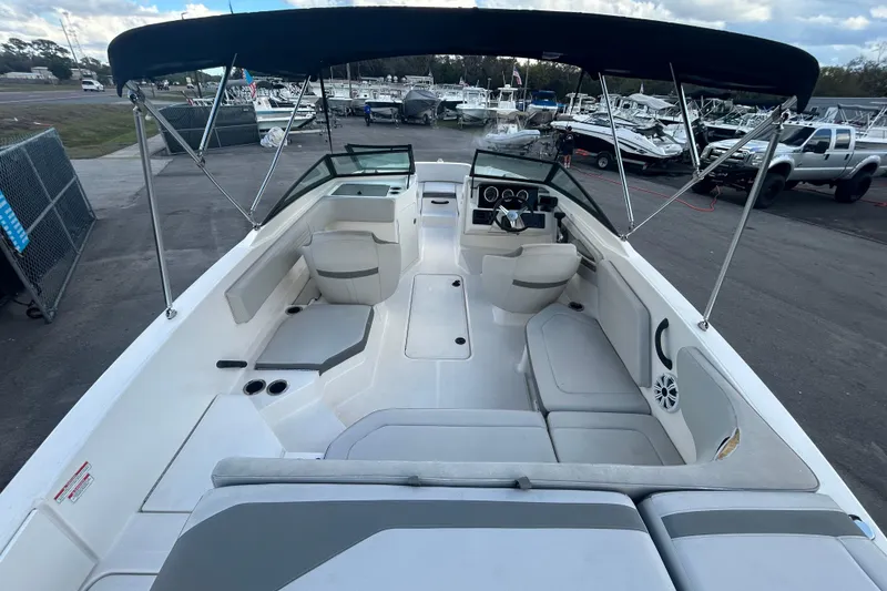 Slide: The Image of 2020 Sea Ray SPX 210 Outboard boat interior with seating and canopy, docked at marina. - 15