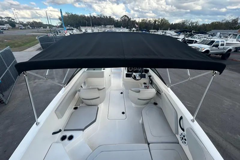 Slide: The Image of 2020 Sea Ray SPX 210 Outboard boat interior with black canopy, docked at marina. - 16