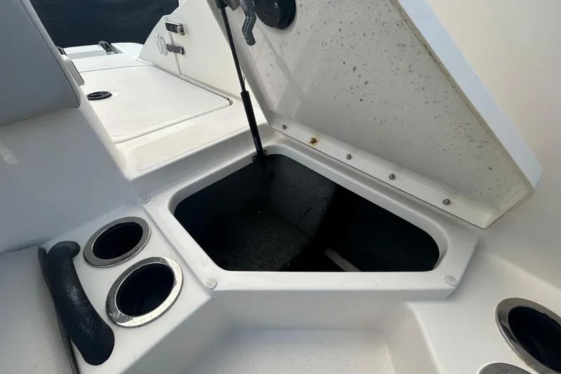 Slide: The Image of Open storage compartment on 2020 Sea Ray SPX 210 Outboard boat with cup holders. - 55