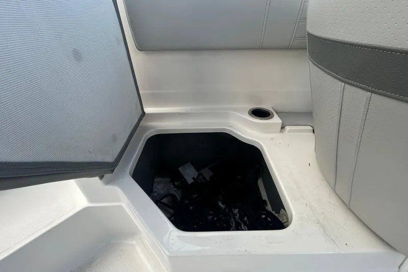 Slide: The Image of Storage compartment on a 2020 Sea Ray SPX 210 Outboard boat, open with visible contents. - 58