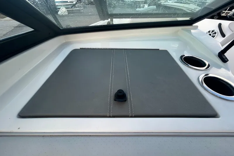 Slide: The Image of 2020 Sea Ray SPX 210 Outboard dashboard with cup holders and storage compartment. - 60