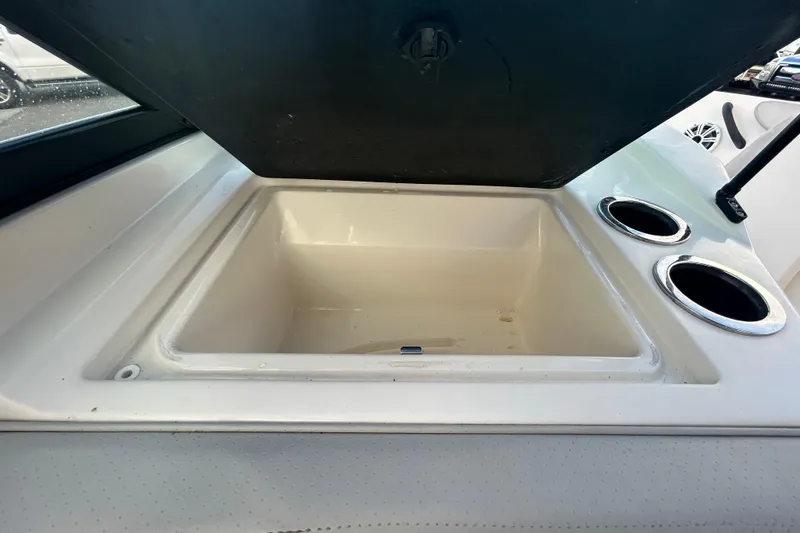 Slide: The Image of Open storage compartment with cup holders on a 2020 Sea Ray SPX 210 Outboard boat. - 61