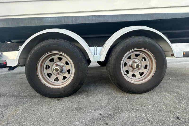 Slide: The Image of Trailer wheels of a 2020 Sea Ray SPX 210 Outboard boat on pavement. - 88