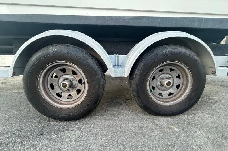 Slide: The Image of Trailer wheels for 2020 Sea Ray SPX 210 Outboard boat on pavement. - 89