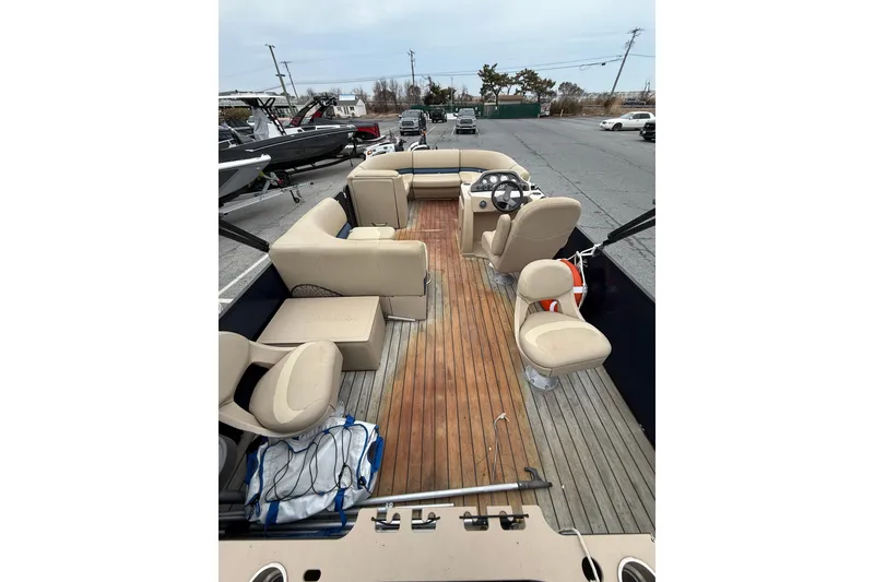 Slide: The Image of 2017 Manitou 22RF pontoon boat with beige seating and wooden deck. - 10