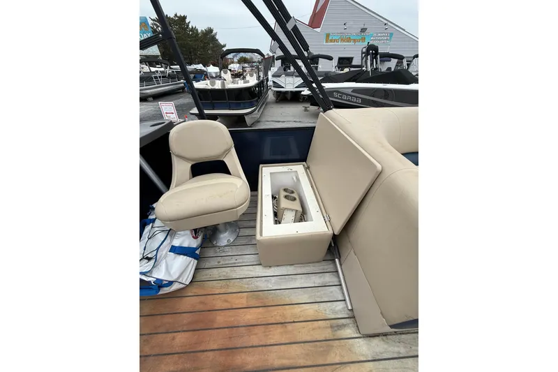 Slide: The Image of 2017 Manitou 22RF boat interior with beige seating and storage compartment. - 15