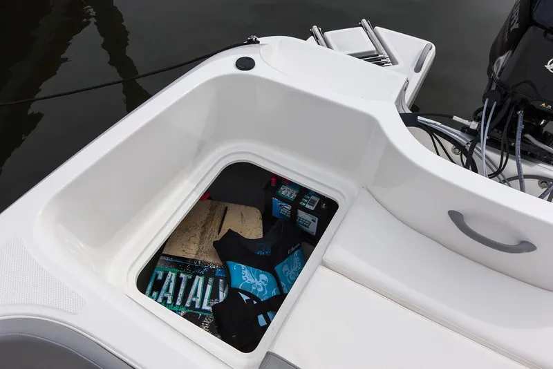 Slide: The Image of 2021 Bayliner Element E16 boat interior with blue and white seating, docked outdoors. - 11