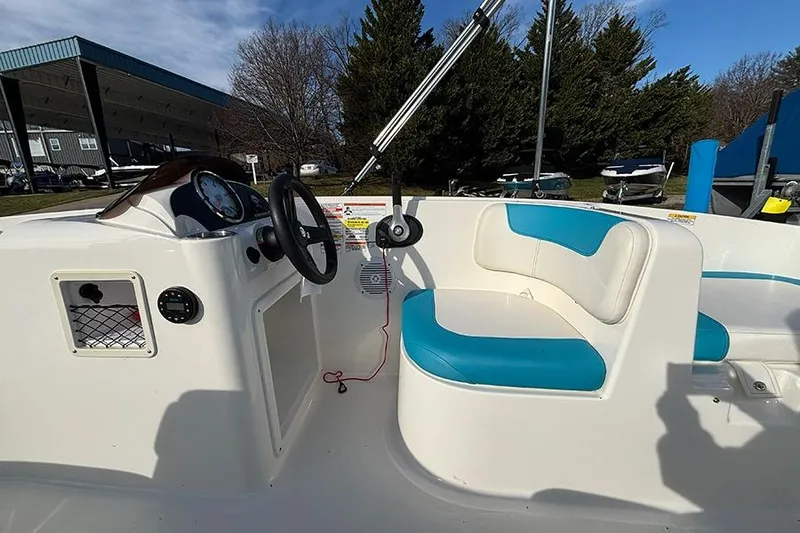 Slide: The Image of 2021 Bayliner Element E16 boat interior with blue and white seating, steering wheel, and dashboard. - 14