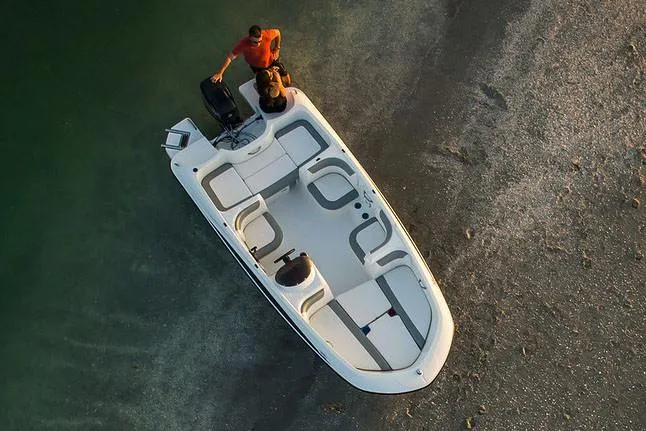 Slide: The Image of 2021 Bayliner Element E16 boat with Mercury outboard motor, parked outdoors. - 5