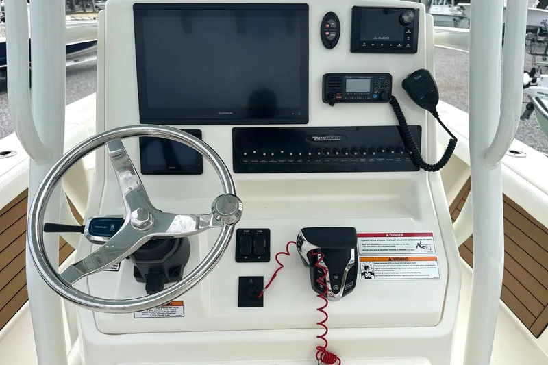 Slide: The Image of 2024 Pathfinder 2400 TRS boat console with steering wheel and electronic controls. - 18