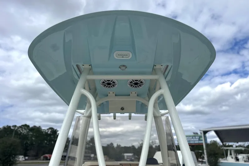 Slide: The Image of 2024 Pathfinder 2400 TRS boat T-top with speakers, under a cloudy sky. - 23