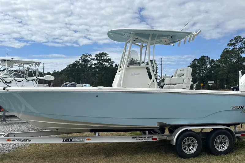 Slide: The Image of 2024 Pathfinder 2400 TRS boat on trailer, side view, under cloudy sky. - 3