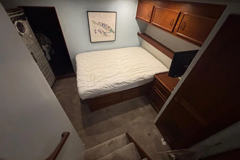 Slide: The Image of Cozy bedroom in 1989 Ocean 48 Motor Yacht with wooden cabinets and nautical decor. - 13