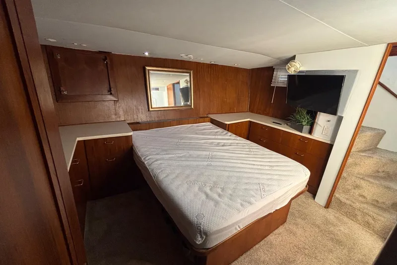 Slide: The Image of 1989 Ocean 48 Motor Yacht bedroom with wood paneling, bed, and TV. - 19