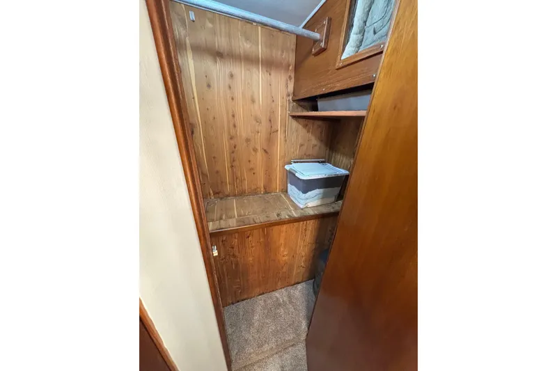 Slide: The Image of Wood-paneled storage area inside 1989 Ocean 48 Motor Yacht, featuring shelves and a storage box. - 21