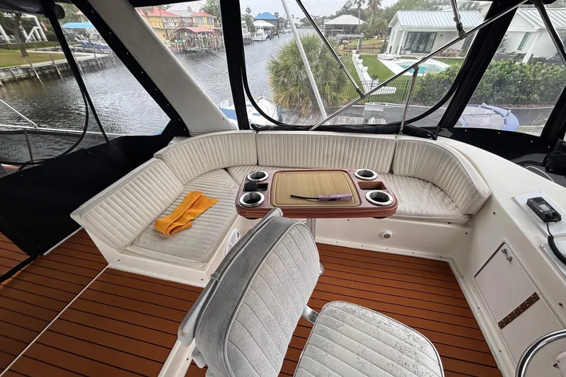 Slide: The Image of 1989 Ocean 48 Motor Yacht interior with seating, table, and waterfront view. - 23