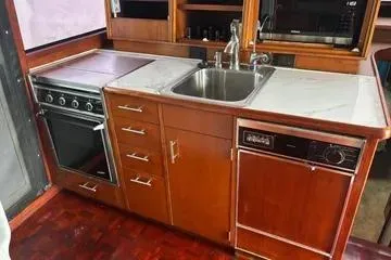 Slide: The Image of 1989 Ocean 48 Motor Yacht kitchen with stove, sink, and dishwasher. - 28
