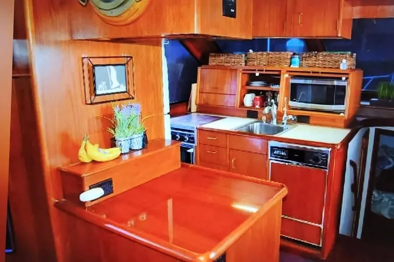 Slide: The Image of Interior of 1989 Ocean 48 Motor Yacht kitchen with wooden cabinetry and modern appliances. - 30