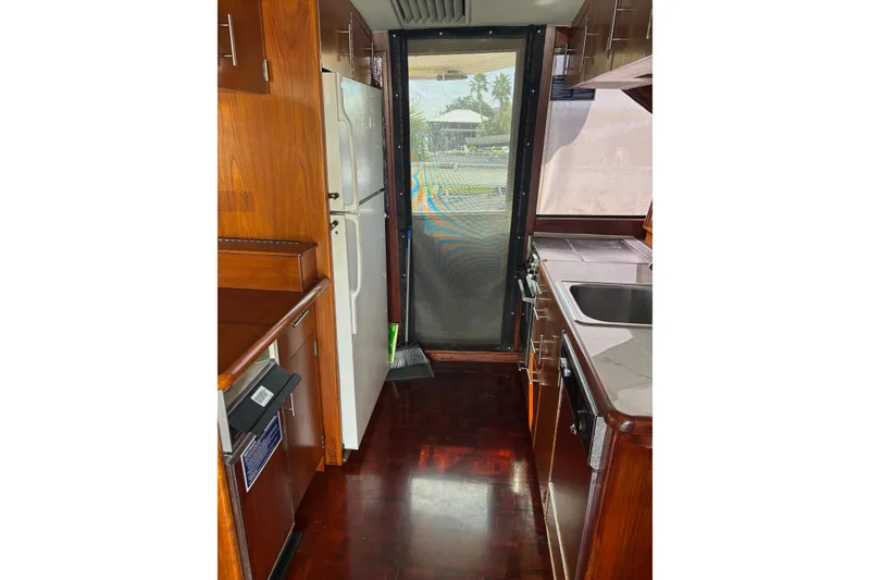Slide: The Image of Interior of 1989 Ocean 48 Motor Yacht kitchen with wood cabinetry and appliances. - 7
