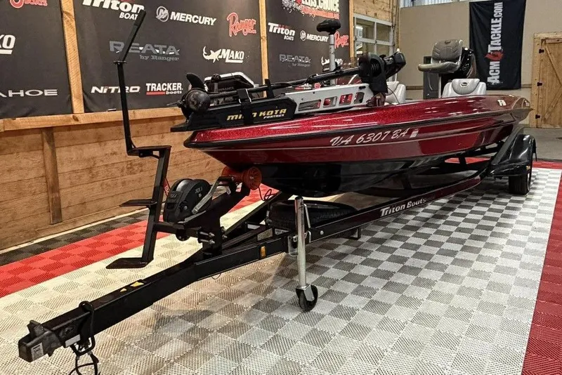 Slide: The Image of 2003 Triton Tr-186 boat on display, red and black, with trailer in showroom. - 6