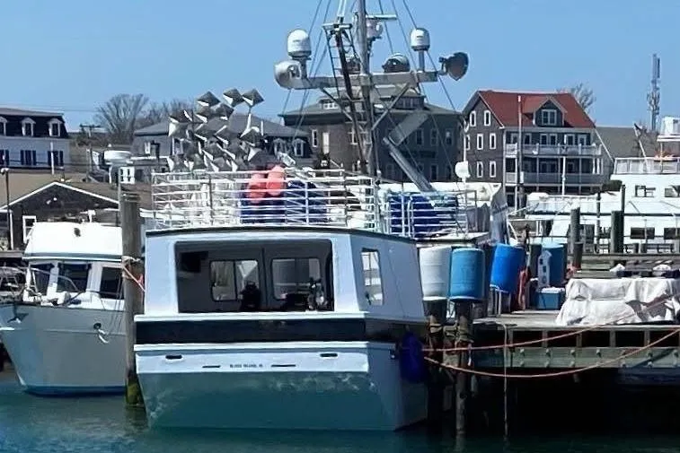 Slide: The Image of Commercial Long Liner boat docked at a marina, surrounded by buildings, 1992 model. - 4