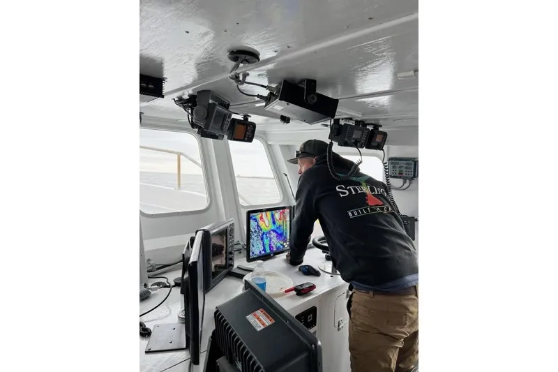 Slide: The Image of Person navigating a 1992 Commercial Long Liner boat using electronic equipment. - 7