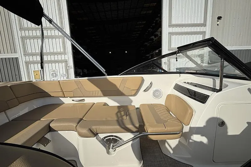Slide: The Image of 2023 Bayliner VR5 Bowrider OB interior with tan seating and open storage area. - 12