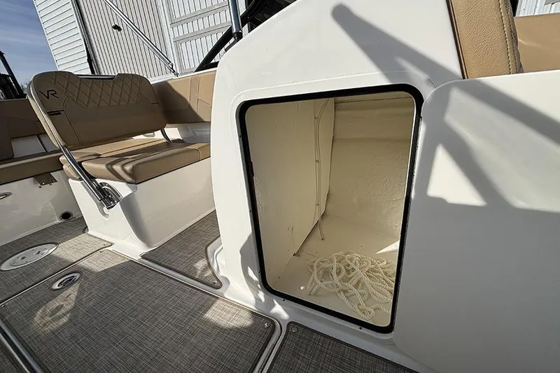 Slide: The Image of 2023 Bayliner VR5 Bowrider OB interior storage compartment with rope, beige seating. - 17