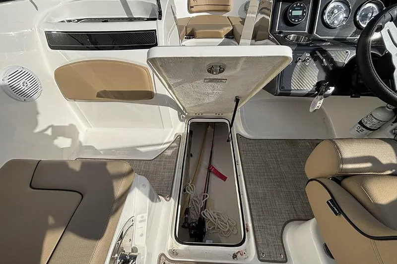 Slide: The Image of 2023 Bayliner VR5 Bowrider OB interior with open storage compartment and fishing gear. - 18