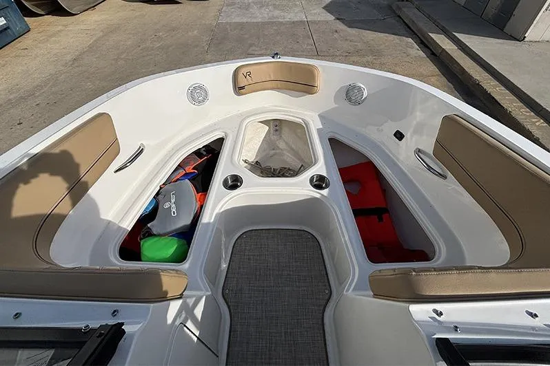 Slide: The Image of 2023 Bayliner VR5 Bowrider OB interior with tan seating and storage compartments. - 22