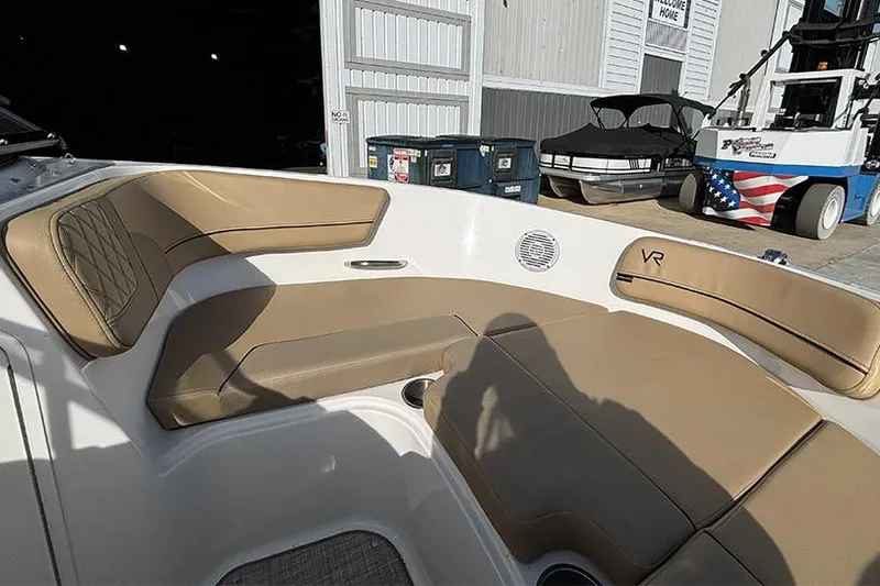 Slide: The Image of 2023 Bayliner VR5 Bowrider OB with tan seating in a marina setting. - 23