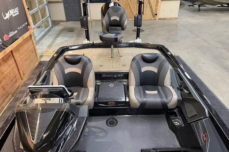 Slide: The Image of 2020 Ranger Z520L boat interior with sleek black and gray seating in a showroom. - 10