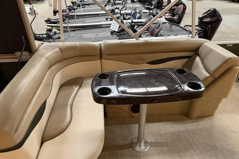 Slide: The Image of 2018 Bennington 21 SLX boat interior with beige seating and a central table. - 13