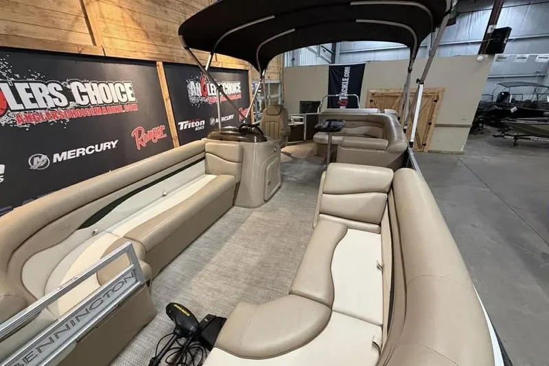 Slide: The Image of 2018 Bennington 21 SLX pontoon boat with beige seating, displayed indoors. - 3