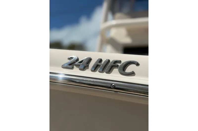 Slide: The Image of 2023 Sea Chaser 24 HFC boat emblem close-up with blue sky background. - 19