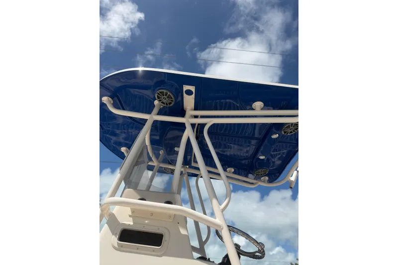 Slide: The Image of 2023 Sea Chaser 24 HFC boat with blue T-top against a cloudy sky. - 5