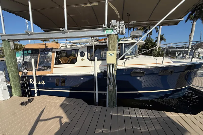 Slide: The Image of 2022 Ranger Tugs R-27 boat docked under a canopy, side view. - 10