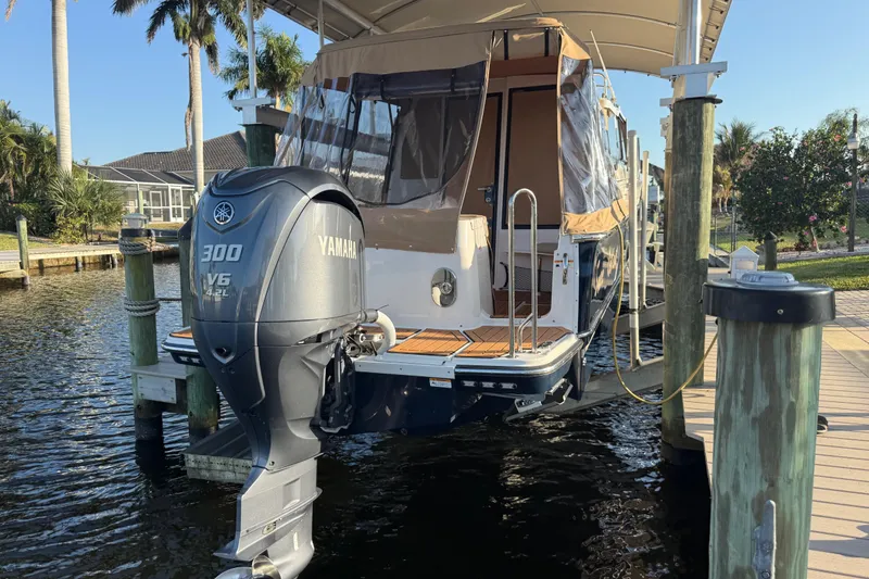 Slide: The Image of 2022 Ranger Tugs R-27 with Yamaha 300 V6 engine docked by palm trees. - 11