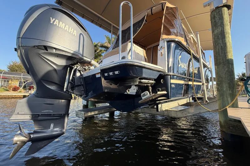 Slide: The Image of 2022 Ranger Tugs R-27 with Yamaha outboard motor on a lift by the dock. - 13