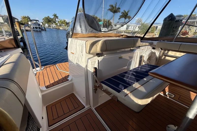 Slide: The Image of 2022 Ranger Tugs R-27 boat interior with seating, table, and water view. - 18