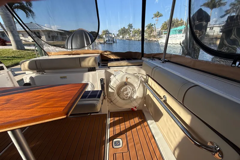 Slide: The Image of 2022 Ranger Tugs R-27 interior with wooden table, seating, and waterfront view. - 19