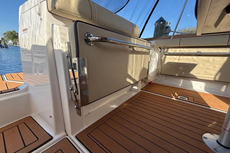 Slide: The Image of 2022 Ranger Tugs R-27 interior with teak flooring and cushioned seating. - 20