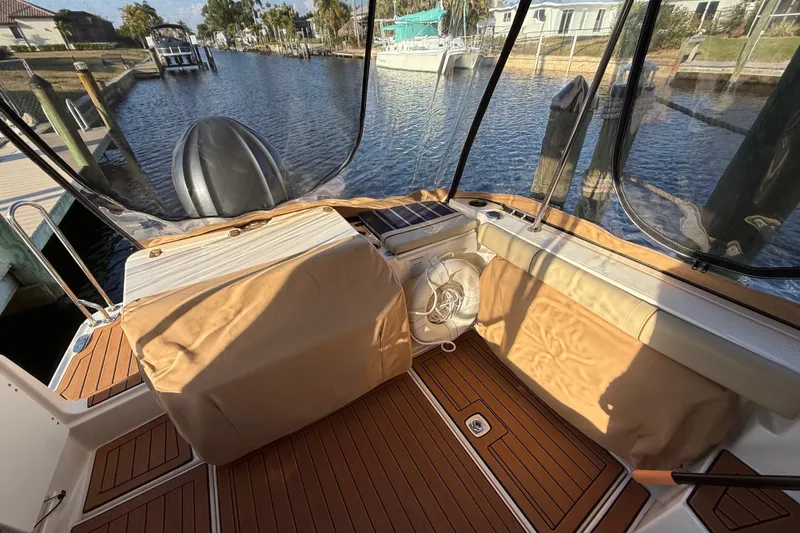 Slide: The Image of 2022 Ranger Tugs R-27 boat interior with covered seating and water view. - 21