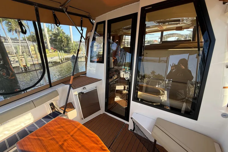 Slide: The Image of 2022 Ranger Tugs R-27 boat interior with seating, table, and large windows. - 26